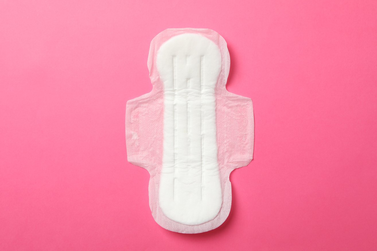 Sanitary pad on pink background, top view